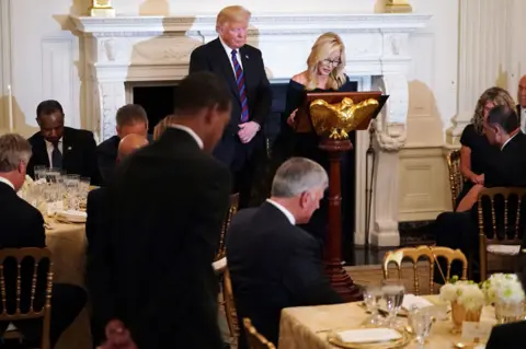 Getty Images Paula White prays with Trump at the White House