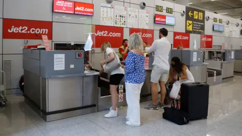 Getty Images Passengers queue up at the Jet2 check-in desk at Palma de Mallorca airport in Mallorca