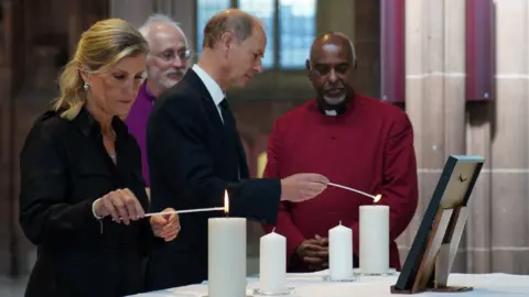 PA Media The Earl and Countess of Wessex lighting a candle at Manchester Cathedral