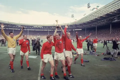 Hulton Archive/Getty Images Bobby Charlton raises the Jules Rimet trophy at Wembley alongside his team mates Gordon Banks, Alan Ball and captain Bobby Moore