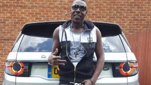 West Midlands Police Carlington Grant posing in front of the rear of a Land Rover