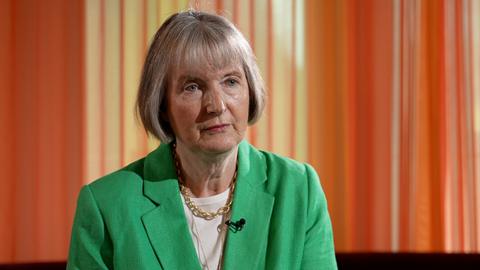 Harriet Harman head and shoulders shot, wearing a green blazer against an orange backdrop as she speaks to Sima Kotecha during a BBC interview