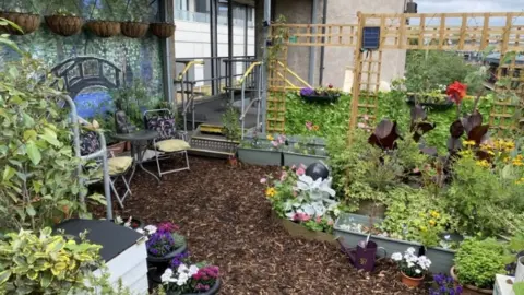 TfL A range of tropical and herbaceous plants spring up in the elevated garden, which is covered in chipped bark.