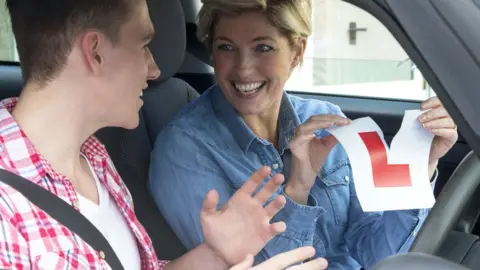 Getty Images Young male driver, with female instructor tearing up