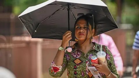 NEW DELHI, INDIA - JUNE 7: People seen out on a hot day at Qutub Minar, on June 7, 2026 in New Delhi, India. The maximum temperature ranged between 40°C and 42°C, while humidity levels fluctuated from 24% to 53% throughout the day, forcing residents to endure intense sunshine and oppressive heat. (Photo by Sanchit Khanna/Hindustan Times via Getty Images)