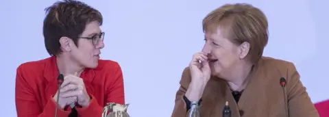 Getty Images German Chancellor and leader of the German Christian Democrats (CDU) Angela Merkel and Annegret Kramp-Karrenbauer sit together during the federal executive board meeting on December 6, 2018 in Hamburg, Germany