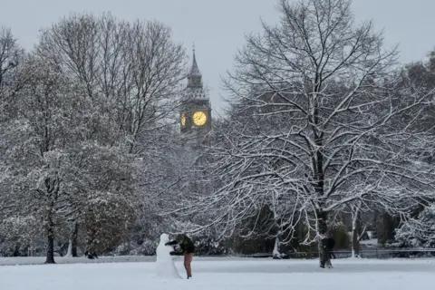Toby Melville / Reuters A person builds a snowman