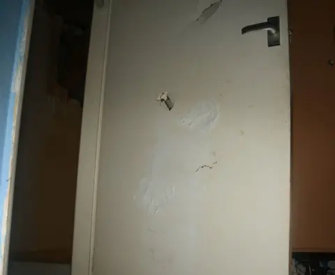 Derbyshire Police Door with holes punched in it