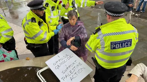Police arrest a woman in Parliament Square, London
