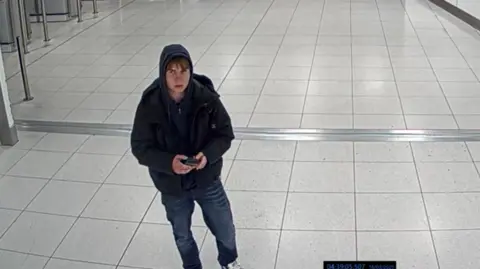 Counter Terrorism Policing A CCTV image of a teenage boy wearing jeans and a hoodie at Manchester Airport