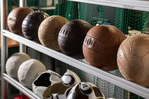 Loughborough University A line of leather footballs lined up on a rail