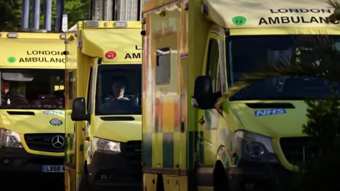 NHS ambulance staff in three ambulances at a hospital in London.