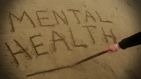 Imaging showing the words mental health written in sand