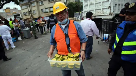 BBC Volunteers kept workers, soldiers, medical staff and the media fed and hydrated with snacks and drinks often passed out from trays or small bags, Mexico City, 2017