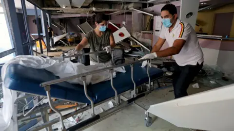 Reuters Staff move a gurney in a damaged hospital