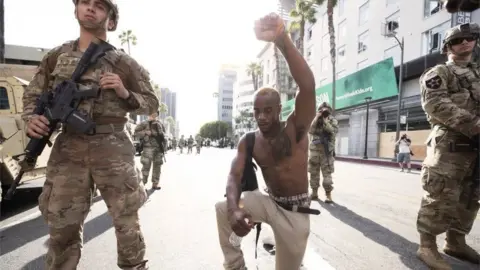 Getty Images A demonstrator kneels during a march in response to George Floyd's death on June 2, 2020 in Los Angeles, California