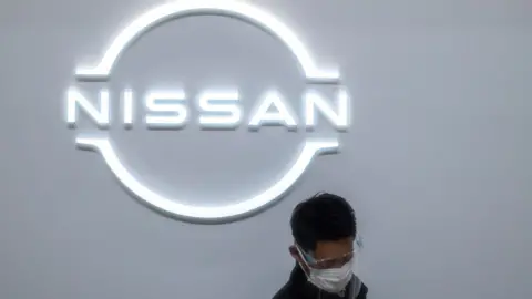 Getty Images A staff member is pictured at the reception of the showroom at the Nissan Motor global headquarters in Yokohama, Kanagawa prefecture