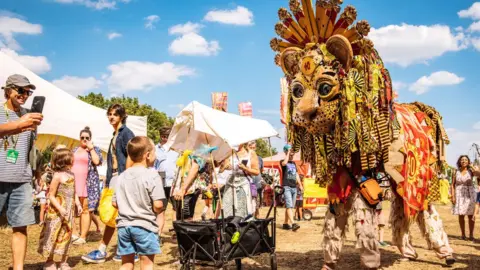 Garry Jones A lion puppet meets festival-goers at WOMAD