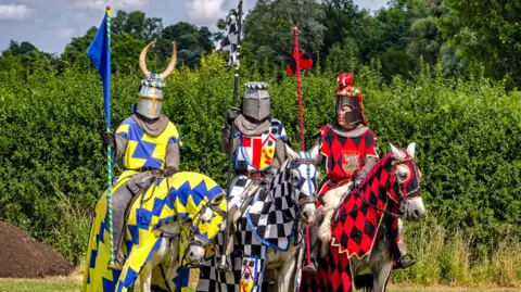 Three knights ready for tournament re-enactment at jousting event at Hever Castle.