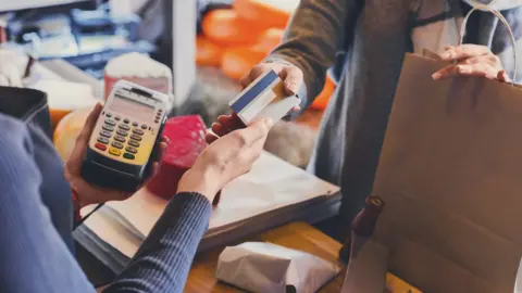 Getty Images person paying with credit card