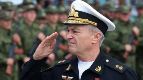 Reuters Viktors Sokolovs, Krievijas Melnās jūras flotes komandieris, sveicina ceremonijas laikā 2022.
