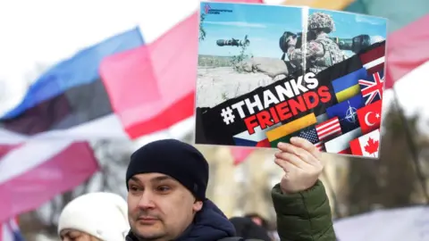 Getty Images A Ukrainian holds a sign thanking Nato for weapons at a protest in Kyiv, January 2022