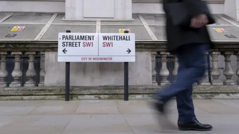 Getty Images Man walking next to Whitehall sign