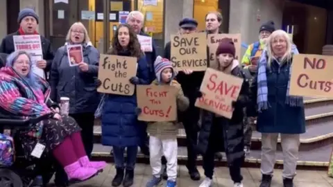 SOSiS Members of Save Our Services in Surrey outside Woking Borough Council offices.