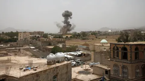 Reuters Smoke rises after a reported air strike in Sanaa, Yemen (9 August 2018)