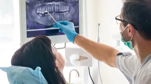 Getty Images Dentist showing a patient an x-ray