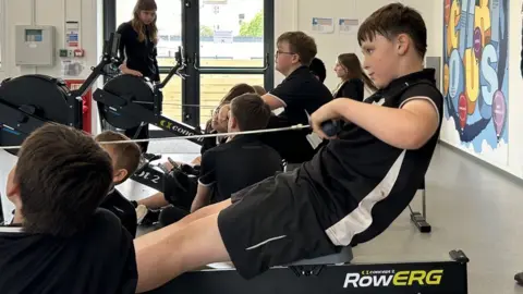 students rowing indoors