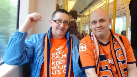 Richard Armstrong Richard Armstrong (right) and his father Calvin in their Luton Town shirts on the way to a game