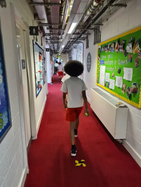 Carl and his classmates keeping three steps behind each other when walking around the school building