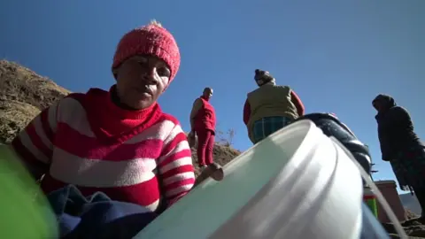 A woman collects water in a bucket