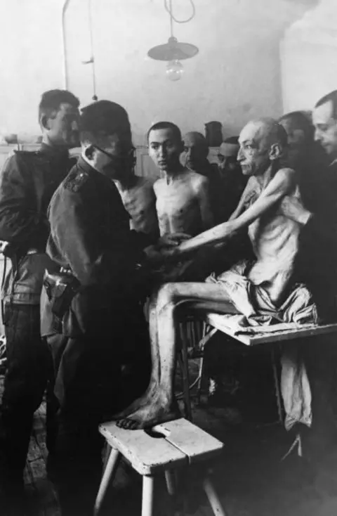 Getty Images Seorang dokter Angkatan Darat Rusia memeriksa orang yang selamat dari Auschwitz di kamp itu 