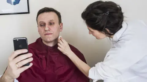 Reuters Opposition leader Alexei Navalny, barred from taking part in the election, has his make-up applied before taking part in a live broadcast in Moscow on 18 March 2018
