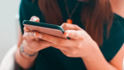 Getty Images Hands holding phone