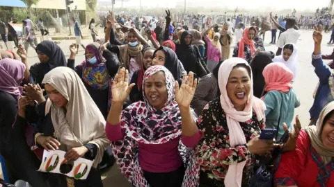 EPA Sudanese people celebrate as they head towards the Army headquarters amid rumors that President Omar al-Bashir has stepped down, in Khartoum, Sudan, 11 April 2019