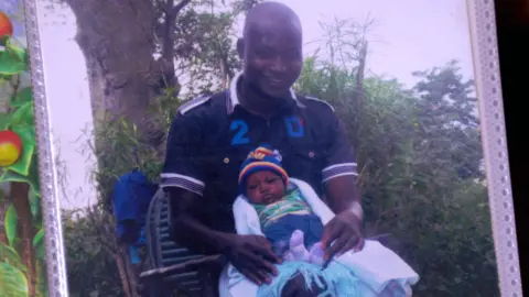 James Masha pictured with one of his children when they were a baby