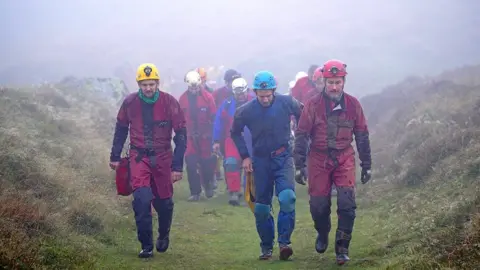 PA Media Rescuers assemble near the Ogof Ffynnon Ddu caves, 8 November 2021