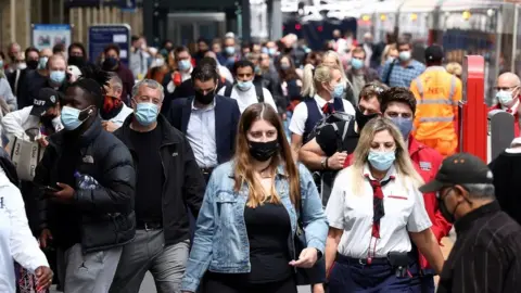 Reuters People wearing face masks walk at King's Cross Station