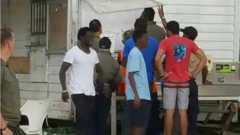 REFUGEE ACTION COALITION A supplied photo of refugees at Manus detention centre checking a notice board