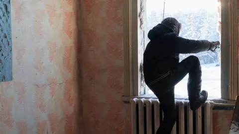 Brice Portolano Ayal comes out through the broken window of an abandoned building after exploring it. It used to belong to an insurance company. Today, Verkhoyansk 1,131 inhabitants live in the village against twice that number 15 years ago.