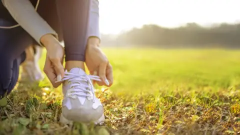 Getty Images Runner tying her shoes