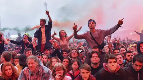 Getty Images Festival-goers sitting on each others' shoulders in a crowd