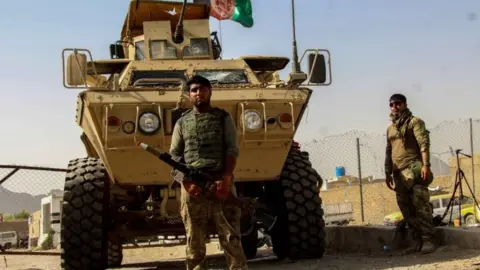 EPA Afghan secuirity forces sit at a checkpoint near the border with Pakistan