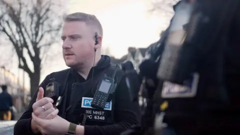 Ant Saddington/BBC PC Michael Gibbs from the mental health street triage team, which will continue