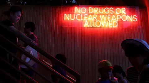 Getty Images A neon sign in Guam makes light of recent nuclear tensions with North Korea