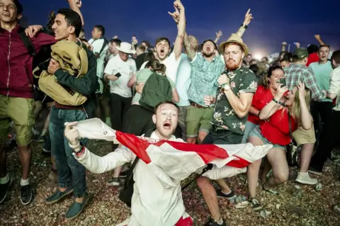 Getty Images England fans celebrate on Brighton beach