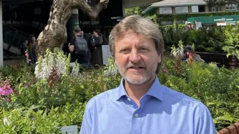 Andrew Moon in front of his sculpture